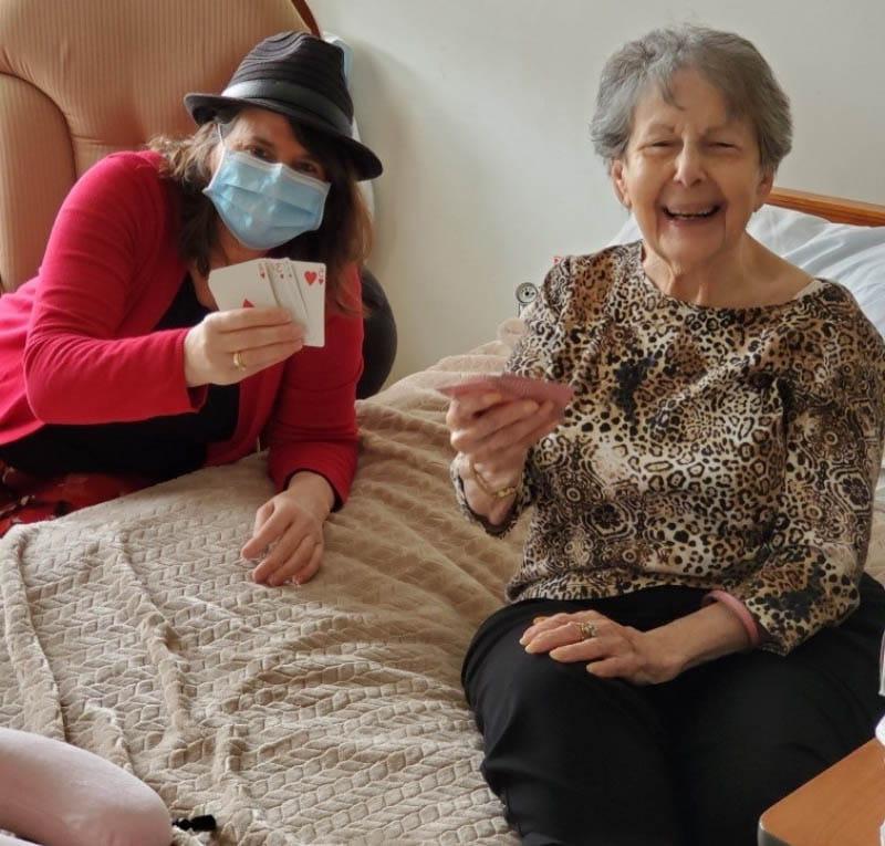 JoAnne Klimovich Harrop (right) playing cards with nursing home resident Rosie Wyner during the COVID-19 pandemic. (Photo courtesy of JoAnne Klimovich Harrop)